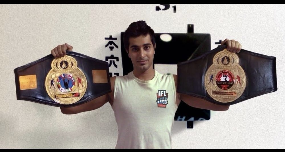 Mah Ghasemi holding two championship belts